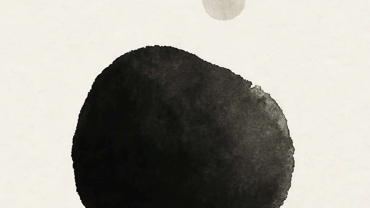 Dunkle, runde Form mit kleinem hellem Kreis darüber. · Dark rounded shape with a small light circle above it.