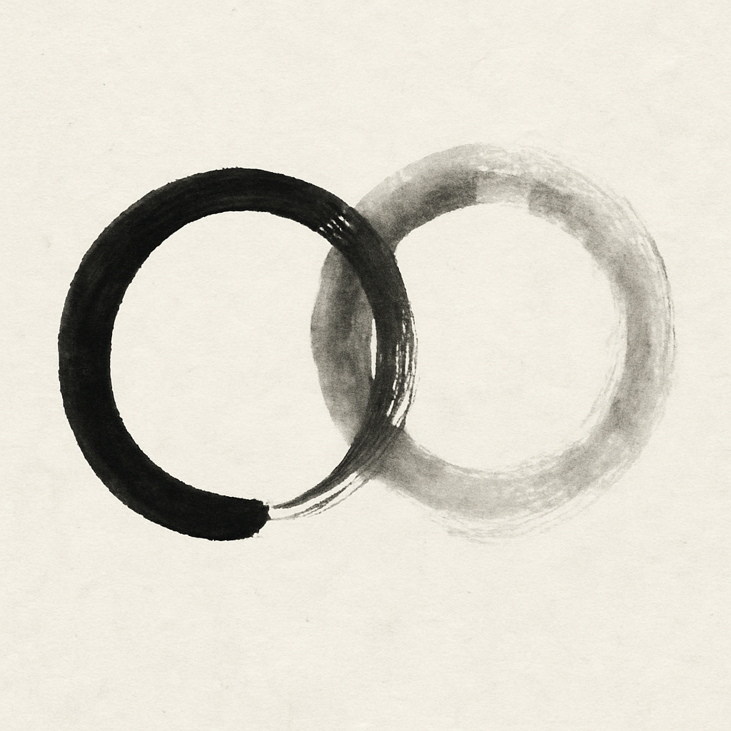 Two circular brushstrokes stand side by side, slightly overlapping in the middle. The left circle is deep black, dense and powerful, with a small opening at the lower edge where the stroke ends. The right circle is much lighter, almost transparent, as if formed of breath or light, its soft edges fading gently into the paper. Where the circles overlap, the tones blend—dark and light greys flowing into one another like two beings touching without consuming each other. The form feels calm, harmonious, alive: a picture of relationship and closeness—two complete circles that overlap without replacing one another. A 'We' formed of two intact 'I's.